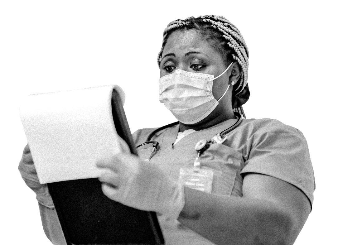 A nurse in scrubs and mask reviewing a patient chart on a clipboard